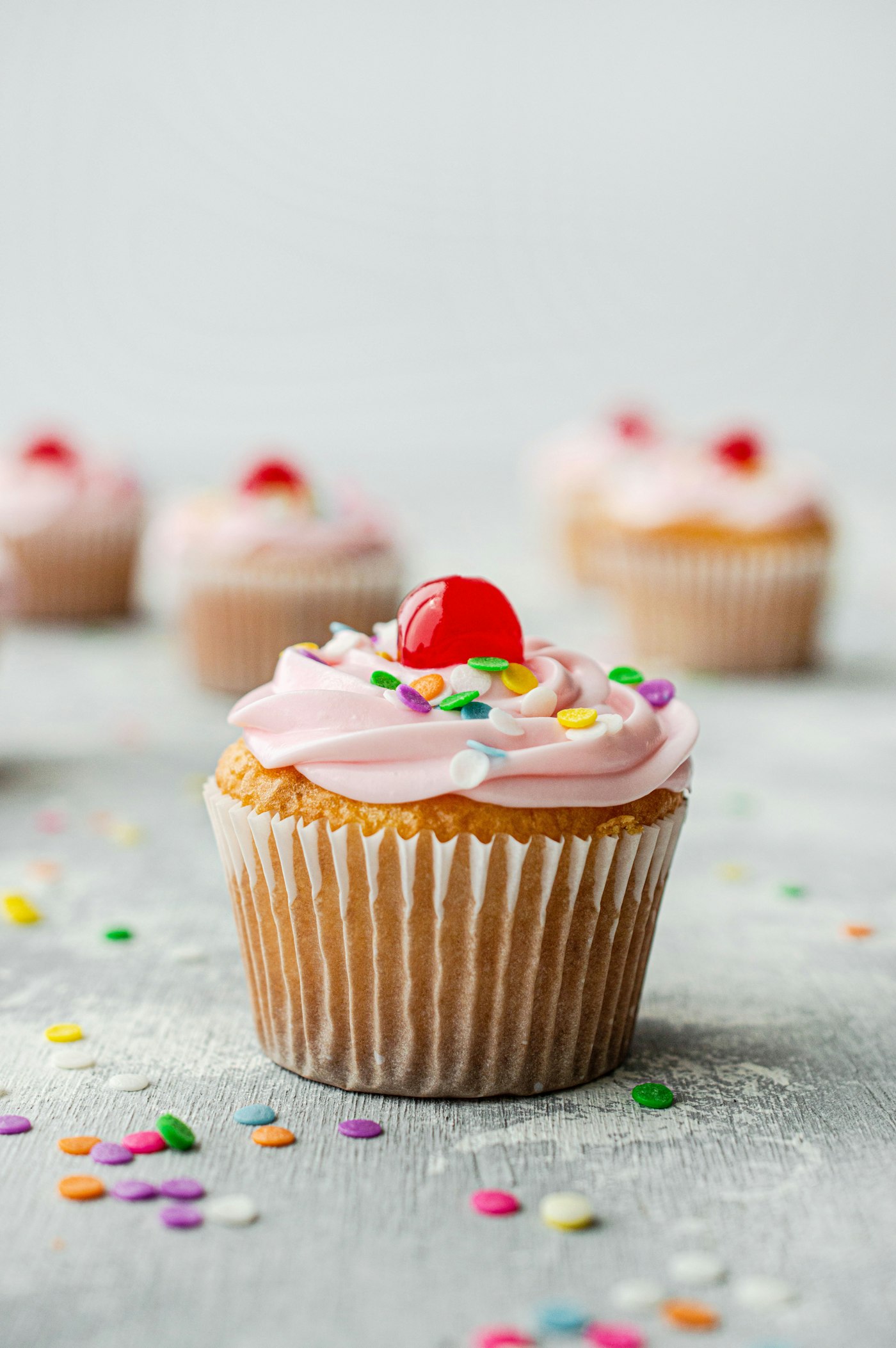 Pink-frosted cupcake topped with a cherry
